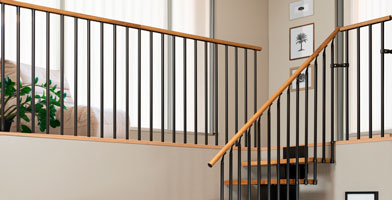 Een overloop met stevige en elegante borstweringen, die houten handgrepen en metalen balusters combineert voor een moderne uitstraling.